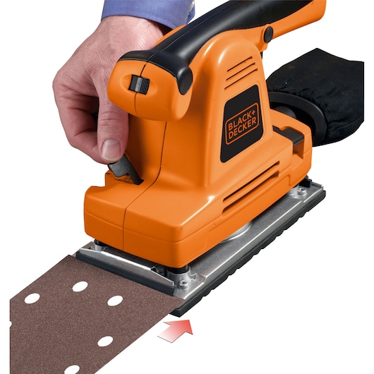 Photo of BLACK+DECKER KA274EKA orange sheet sander with black handle, close-up showing sandpaper installation.