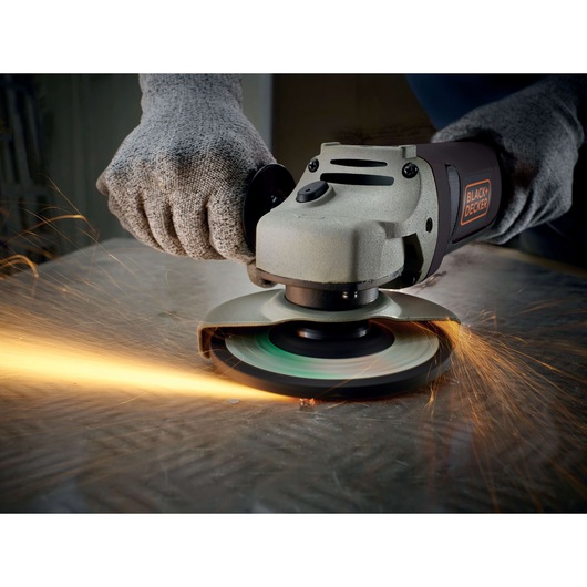 BLACKDECKER KG1202K angle grinder in use, cutting metal with safety gloves, sparks flying.
