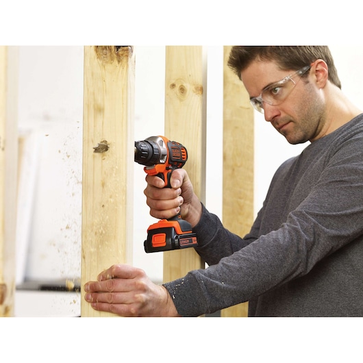 Photo of BLACKDECKER MT218KB cordless drill in use drilling through vertical wooden beams.