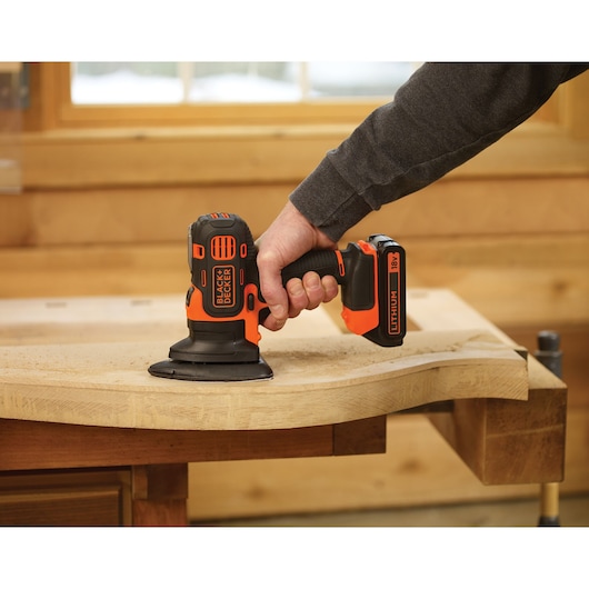 BLACKDECKER MTSA2 cordless sander with 18V battery, used on a wooden surface in a workshop.