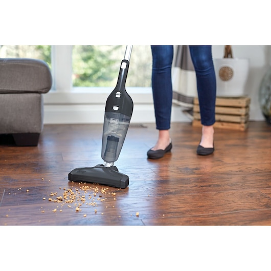 BLACKDECKER NSVA315J cordless stick vacuum cleaning crumbs from hardwood floor in home.