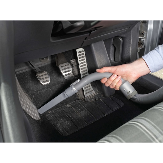 BLACKDECKER PD1200AV handheld vacuum cleaning car pedals and floor mat, close-up angle.