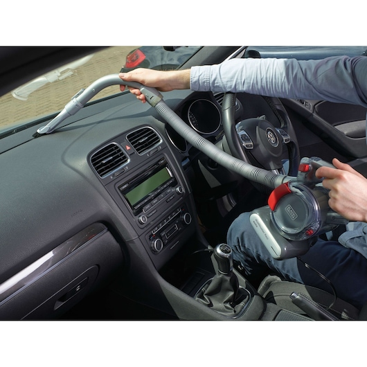 BLACKDECKER PD1200AV car vacuum cleaner used to clean dashboard, flexible hose and compact design visible.