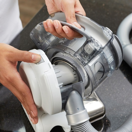 BLACKDECKER PD1820L handheld vacuum filter compartment being opened on a black countertop.