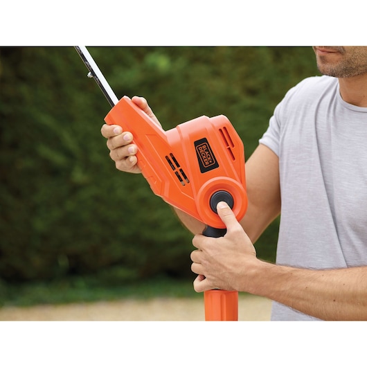 BLACKDECKER PH5551 orange hedge trimmer handle held by person outdoors.