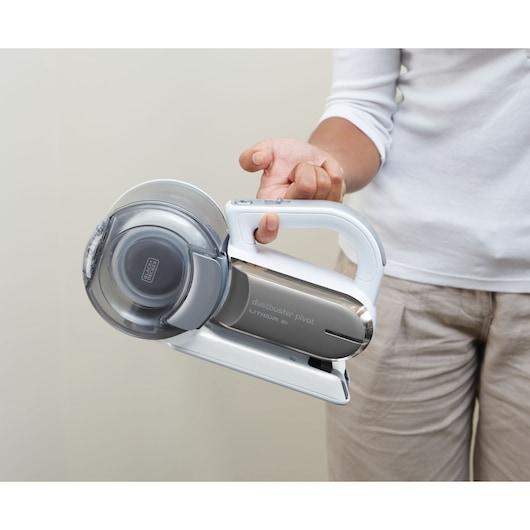 Photo of BLACK+DECKER PV1820L handheld vacuum cleaner being held by a person, silver and white design.