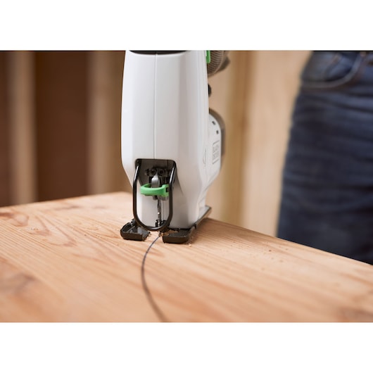 BLACKDECKER REVJ12C cordless jigsaw cutting wood close-up, photography side angle.