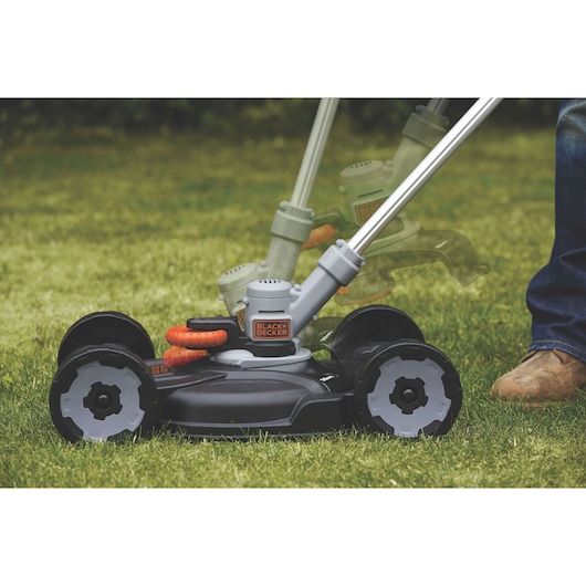 BLACK+DECKER STC1820CM compact lawn mower with adjustable handle, close-up on green grass.