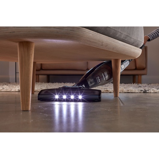 BLACKDECKER SVB620JW cordless vacuum with LED lights cleaning under furniture on hardwood floor.