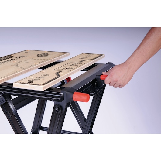 BLACKDECKER WM1000 workbench side angle showing red handle adjustment and printed measurement guides.